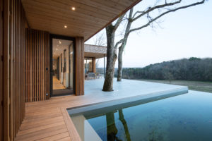 Vue extérieure, terrasse et bassin naturel dominant la vallée / Benoit Bost