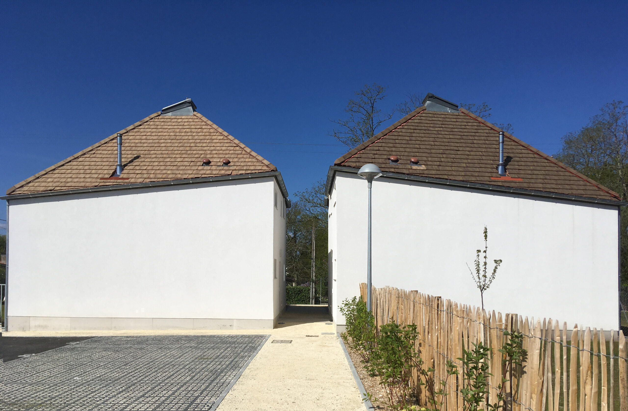 Façades Est depuis l'espace de stationnement central / AVA