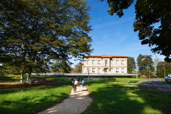 l'extension de fond dans la topographie du parc et sert de socle au château abritant les hébergements / Arthur Pequin