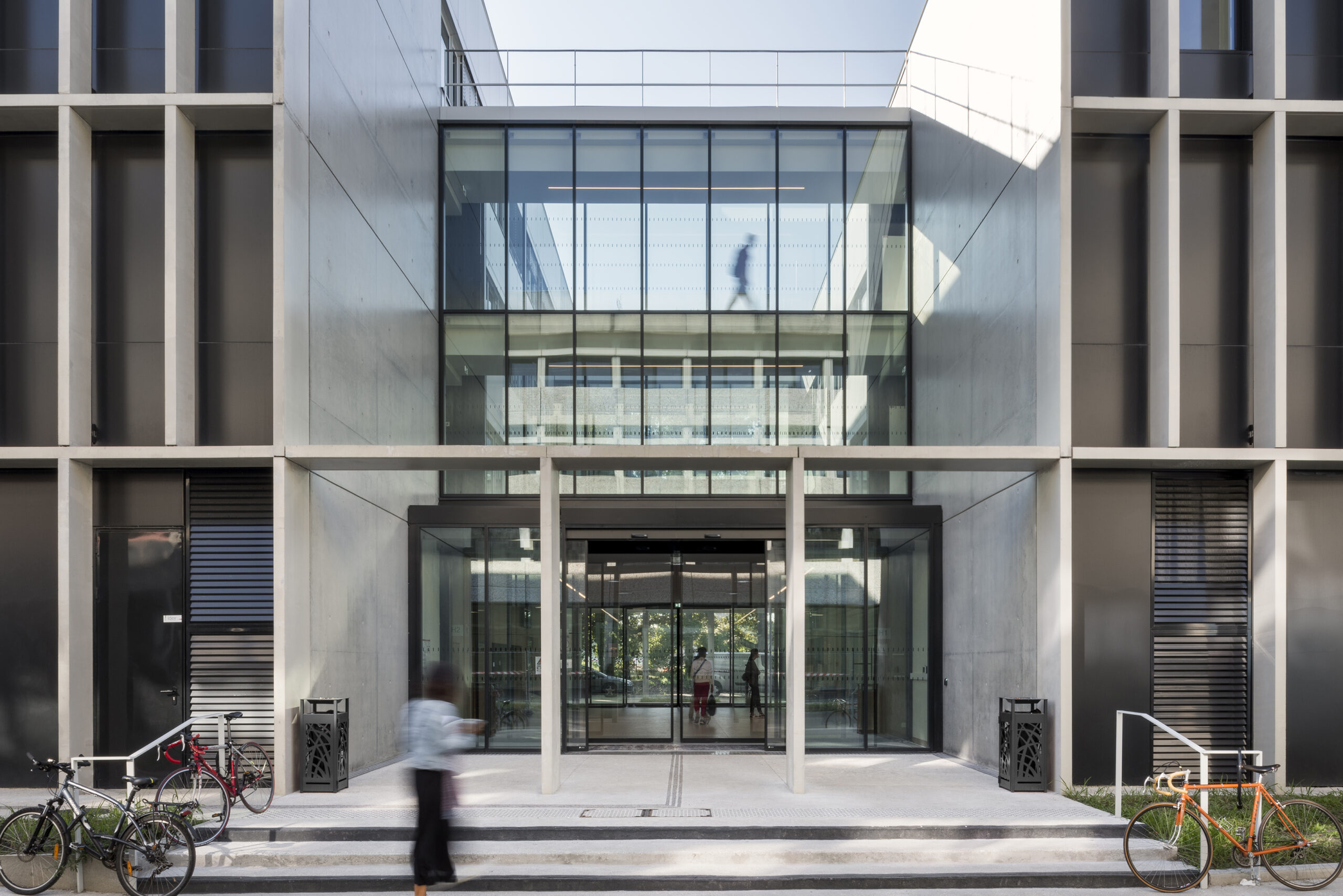 l’entrée principale prend la forme d’une faille généreusement vitrée permettant de traverser le bâtiment du regard / Jean-François Tremege