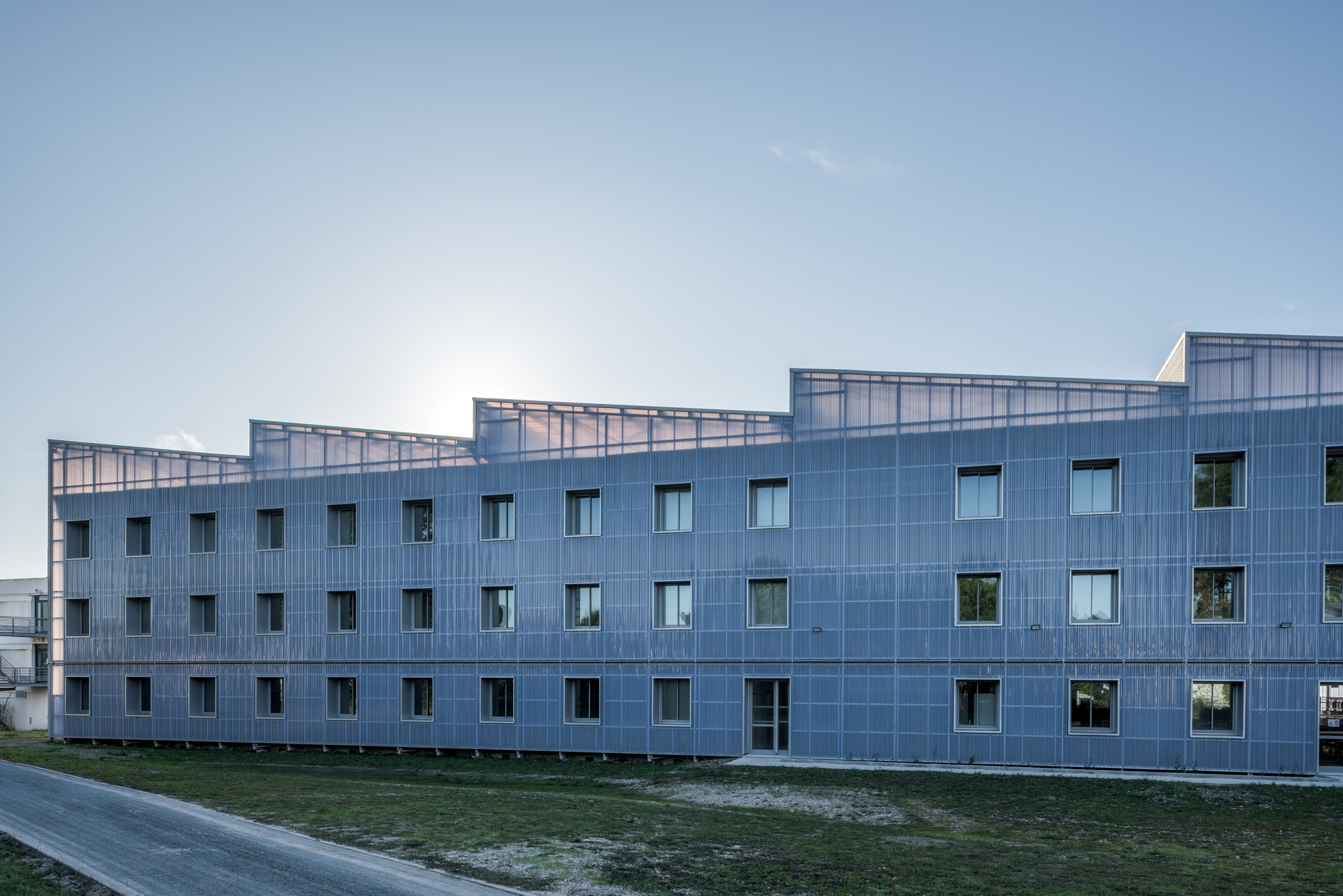 Façade en polycarbonate et toiture Shed en transparence avec la lumière / Jean-François Trémège