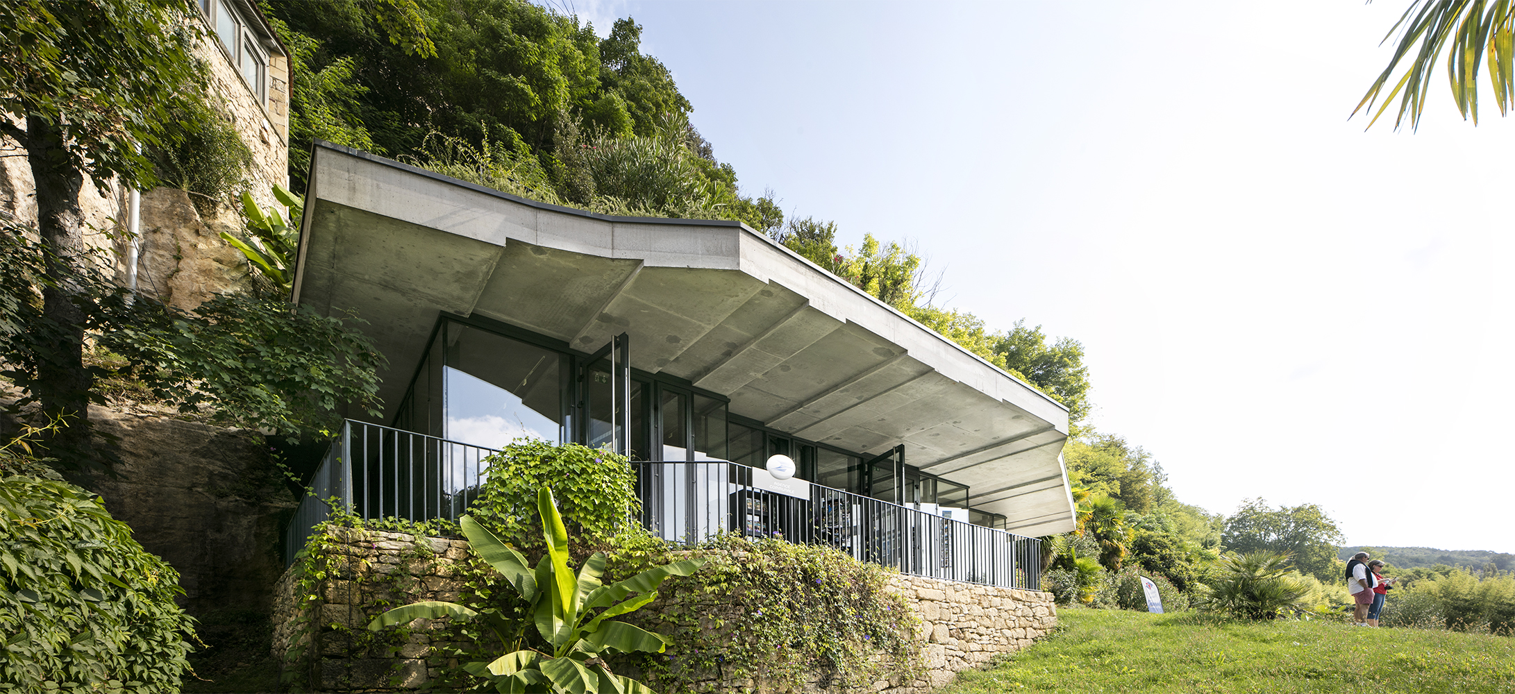 une façade vitrée, qui établit un lien entre l’intérieur et le paysage environnant, une toiture en débord, supportant le jardin exotique / Edouard Decam